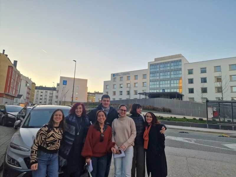 cinco mujeres y un hombre médicos residentes de la HULA junto a la secretaria de la SGXX reunidos felices con el Centro Integral de Saúde de Lugo a sus espaldas